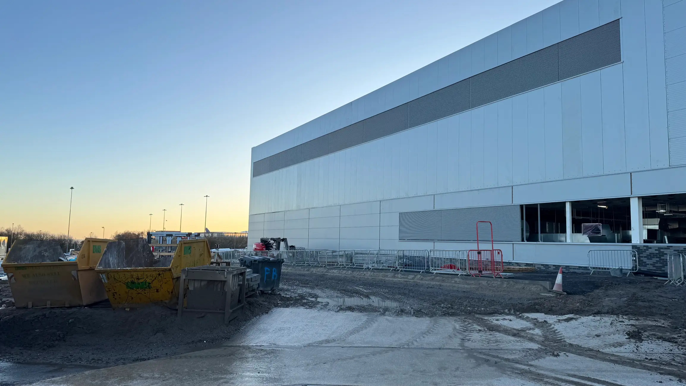 Dumpsters and containment barriers at retail location managed by LDR Site Services.