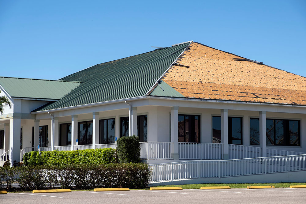 Natural disaster and its consequences. Hurricane Ian destroyed house roof in Florida residential area.