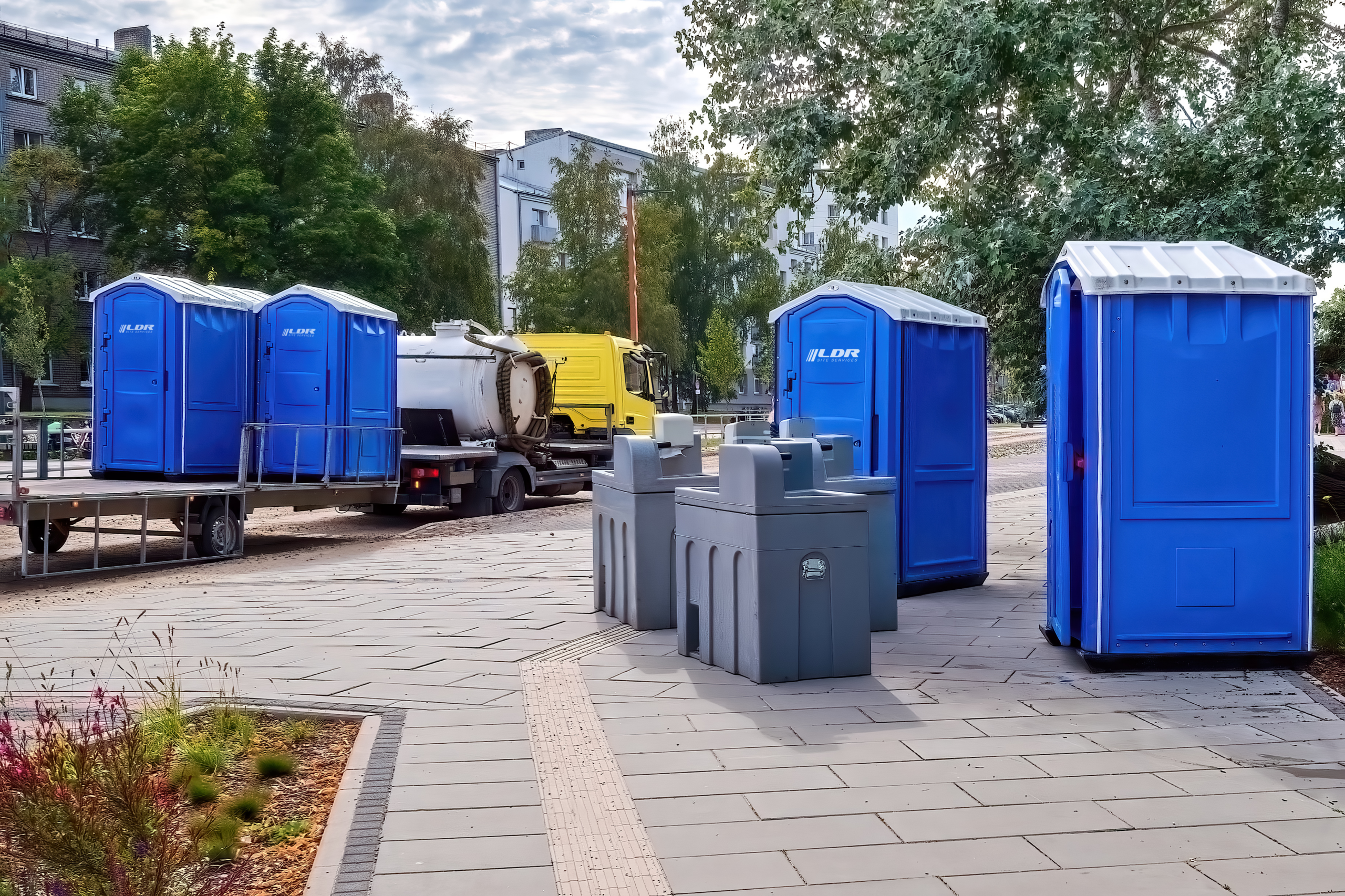 LDR Site Services portable restrooms and hand wash stations set up on a paved plaza with pump-out service truck