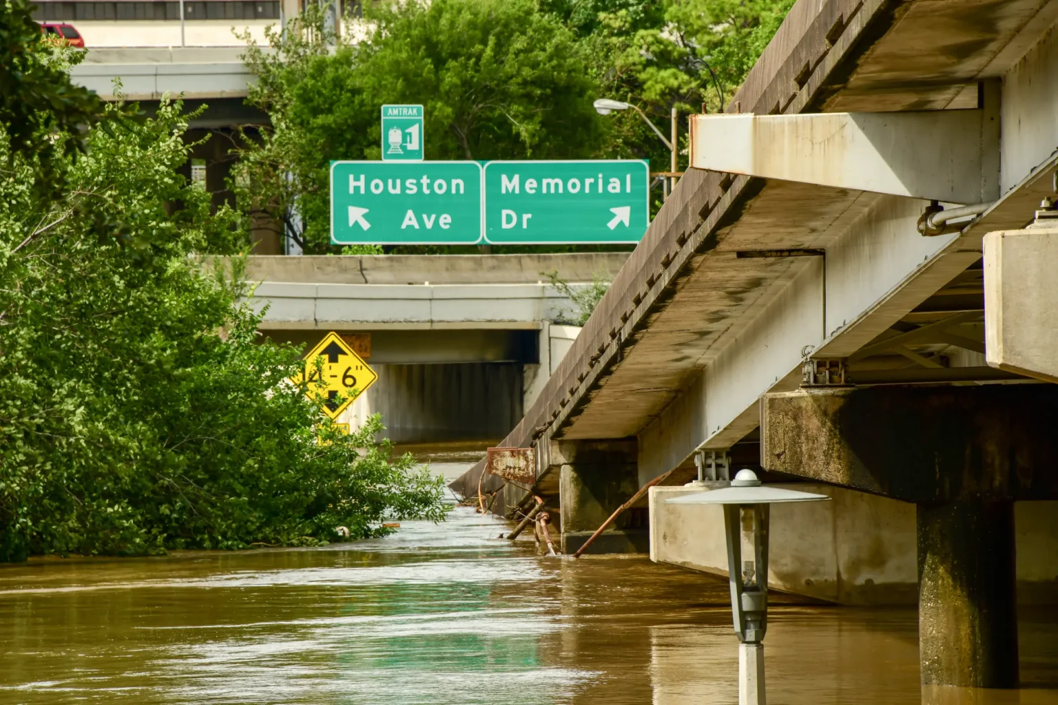 The Houston Ave underpass at Memorial Dr in downtown Houston, floodwater across the low point of the roadway.